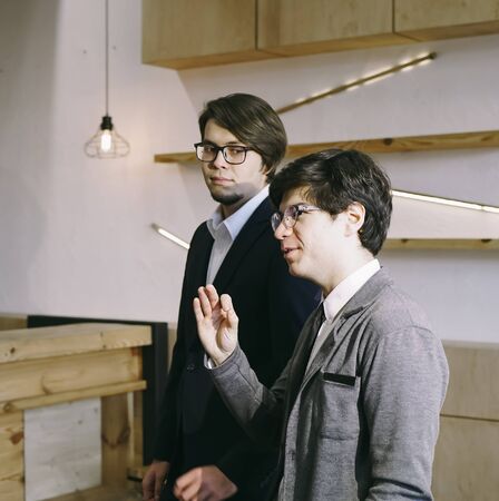 Group of business people in a meeting standing grouped in a officeの写真素材
