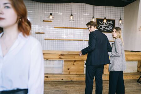 Two coworkers Staring and Gossiping About Their Female Colleague