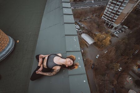 Woman practicing yoga on the roof and doing yoga exercises