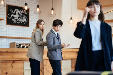 Two coworkers Staring and Gossiping About Their Female Colleague