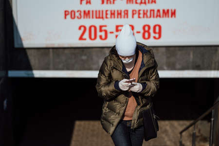 Kiev, Ukraine, March 28, 2020, A woman exits the subway with a phone in her handsのeditorial素材