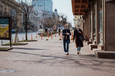 Kiev, Ukraine, March 28, 2020, Ukrainian people at facial protective masks at almost empty street, quarantine time at Ukraine,のeditorial素材
