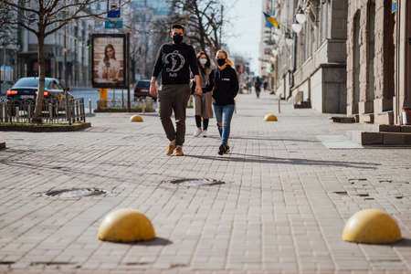 Kiev, Ukraine, March 28, 2020, Ukrainian people at facial protective masks at almost empty street,...