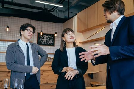 Group of business people in a meeting standing grouped in a office