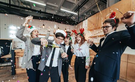 Happy colleagues in office celebrate special event.の写真素材