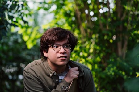 Male scientist hiding in the thicket. Nature protection concept.
