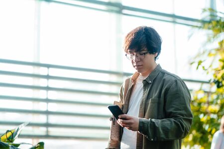 Male scientist looking for something on a smartphoneの写真素材