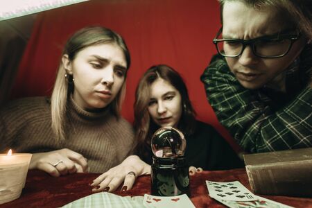 Group of people and woman fortune teller with crystal ball