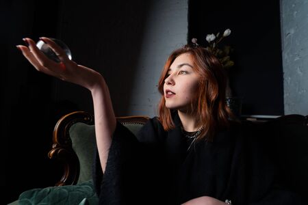 Woman in black suit holding crystal ballの写真素材