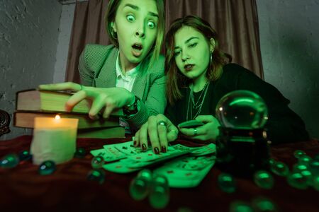 Fortune teller forecasting the future to woman with cardsの写真素材