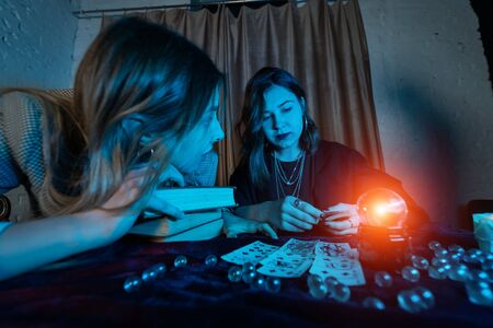 Fortune teller forecasting the future to woman with cardsの写真素材