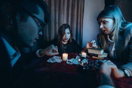 People hold hands of night at table with candlesの写真素材