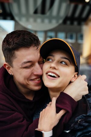 Guy and a girl are hugging at a table in a outdoor cafe.の写真素材