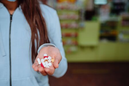 A woman takes and shows pills, vitamins or pills in hand. Health and treatment concept.の写真素材