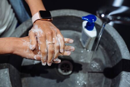 Woman washing hands to protect against the coronavirus.の写真素材