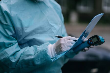Doctor epidemiologist fighting with coronavirus COVID-19. Nurse wears a protective suit and mask...