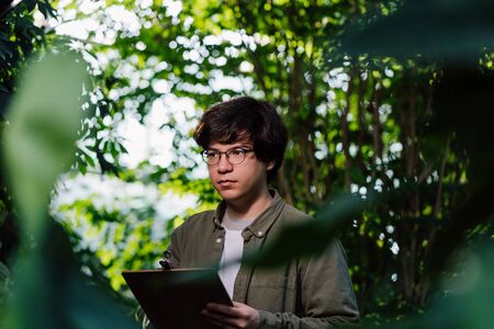 Nature protection concept. Male scientist carefully studies his dataの写真素材