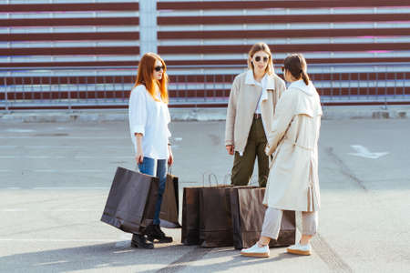 Young women with bags in hands posing for the camera