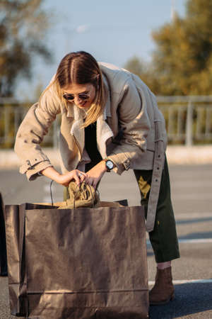 Young woman with shopping bags on parking