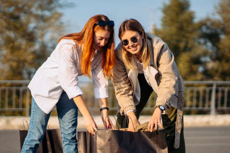 Young women with shopping bags on parkingの写真素材