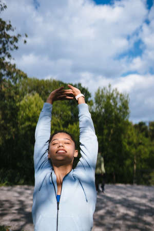 Girl in sports uniform warming up before jogging
