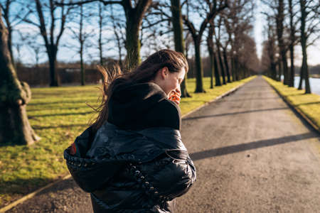 Portrait of a brunette girl having fun in a park in the rays of the bright sun.の写真素材