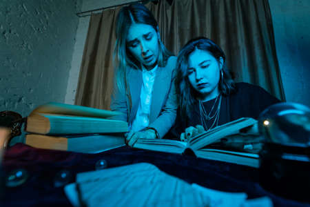 Two women are reading a mysterious book