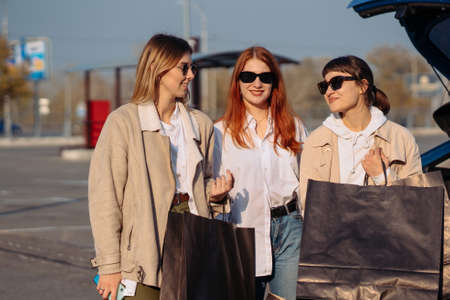Young women at the car with shopping bagsの写真素材