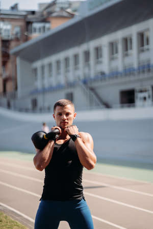 Sportive guy training with kettlebell. Strength and motivation.