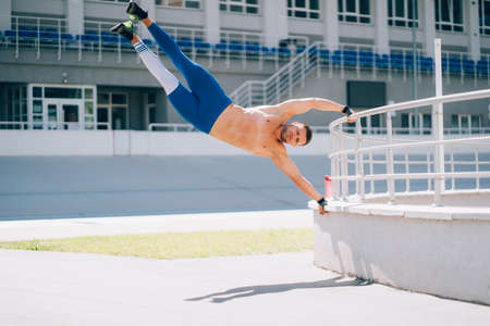 Young athletic man performs gymnastic elements - human flag.の写真素材