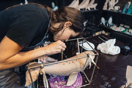 Portrait of young woman enjoying favorite job in workshop.