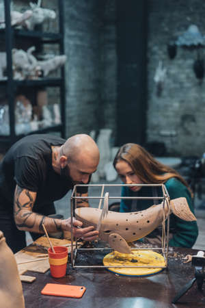 People carefully work on clay whale in workshopの写真素材