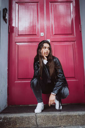 Young woman outdoor against a red door