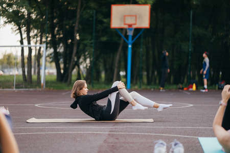 Young fit woman in sportswear trains outdoors on the playground.の写真素材