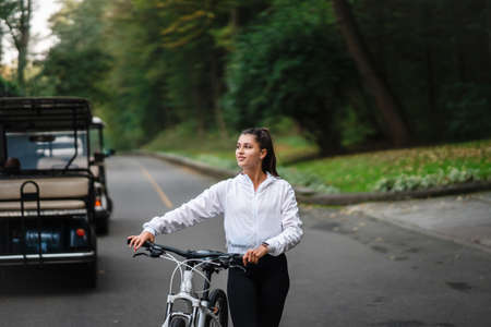 Beautiful girl posing at white bicycle. Walk in nature.