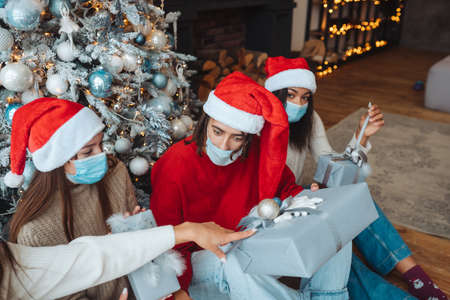 Multiethnic group of friends in Santa hats with gifts in hands.の写真素材