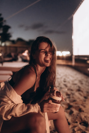 Young woman is sitting on chair at night beach
