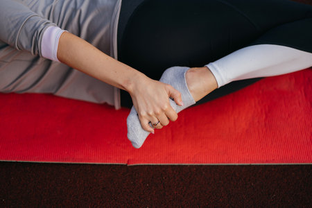 Young fit woman in sportswear trains outdoors on the playground.の写真素材