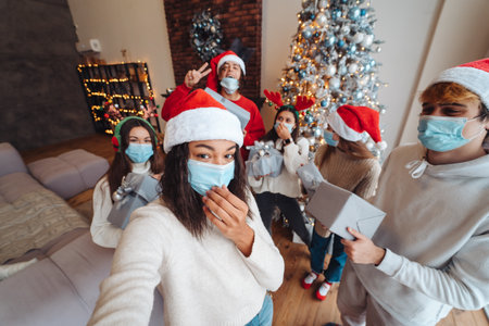 Multiethnic group of friends in Santa hats with gifts in hands.