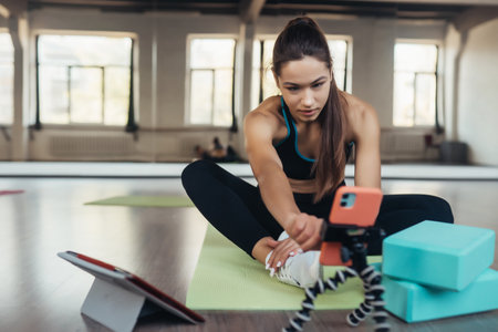 Young woman practicing yoga, is engaged with the teacher online.