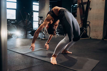 Slim athletic woman doing exercise bridge at gymの写真素材