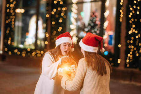 The girl gives a gift to her female friend on the street.の写真素材
