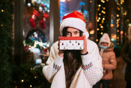 Young woman giving box for you outdoor. Gift exchange concept.の写真素材