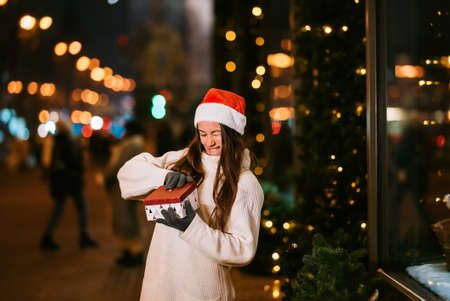 Night street portrait of young beautiful woman acting thrilled.の写真素材