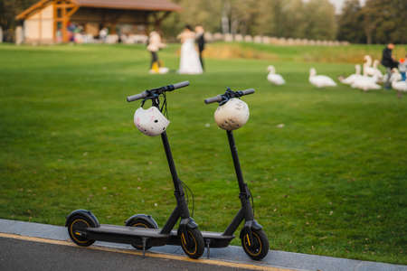 two electric kick scooters or e-scooter parked on the sidelines road