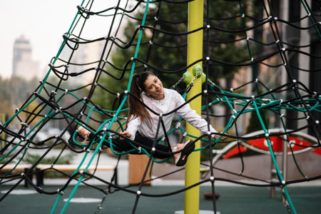 Young woman having fun on the rope pyramidの写真素材