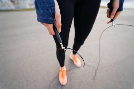 Young woman exercise with skipping rope outdoors