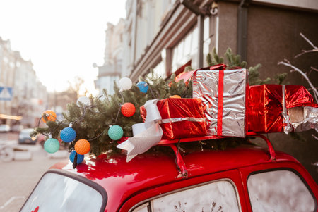 Red retro car with a Christmas tree fir tied to the roof.の写真素材