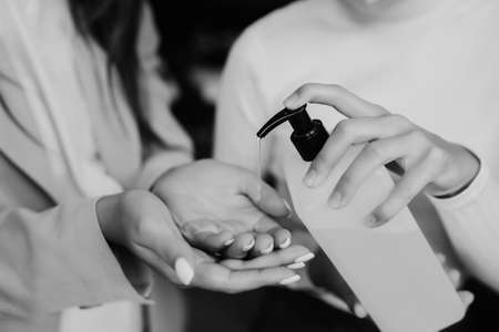 Female hands applying antibacterial liquid soap close up.の写真素材