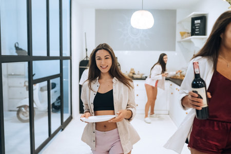 The girls are setting the table for dinner. Carry food from the kitchen to the tableの写真素材